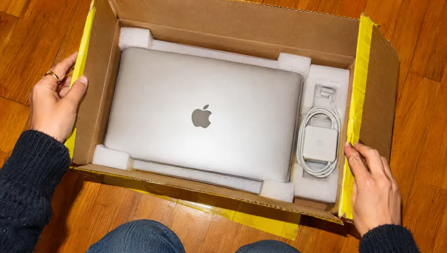 Caja abierta con una MacBook Air y su cargador